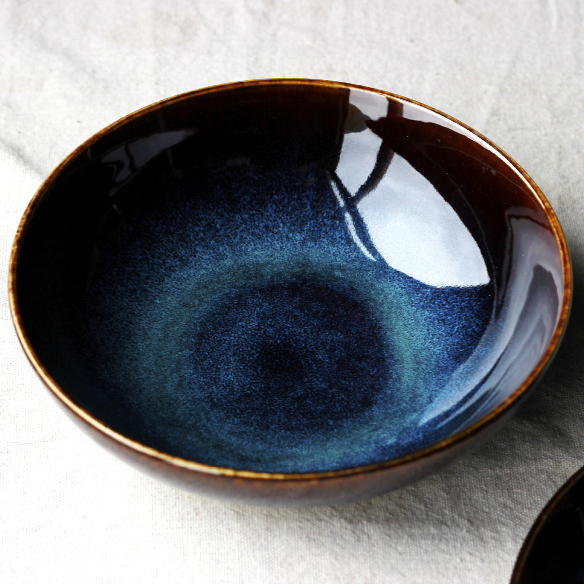 Blue kiln porcelain shallow bowl closeup showing deep blue glaze finish

