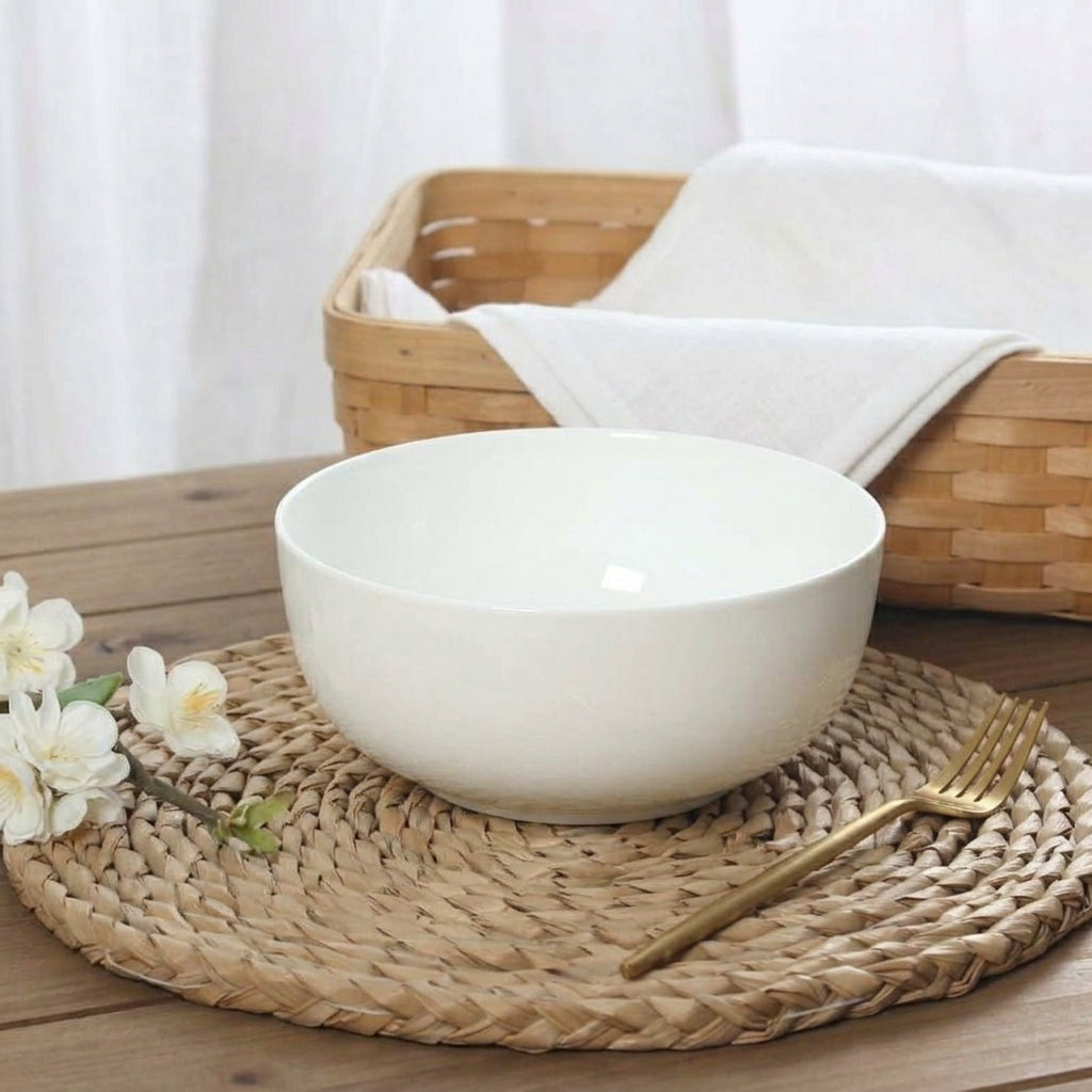White bone porcelain soup bowl on woven wicker tray with basket in background
