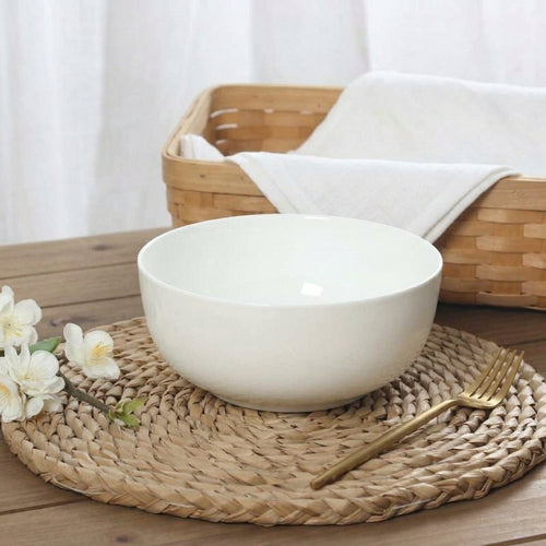 White bone porcelain soup bowl on woven wicker tray with basket in background
