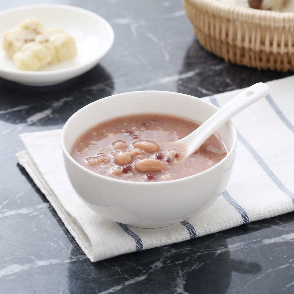 White porcelain soup bowl with pink dessert and spoon on marble surface
